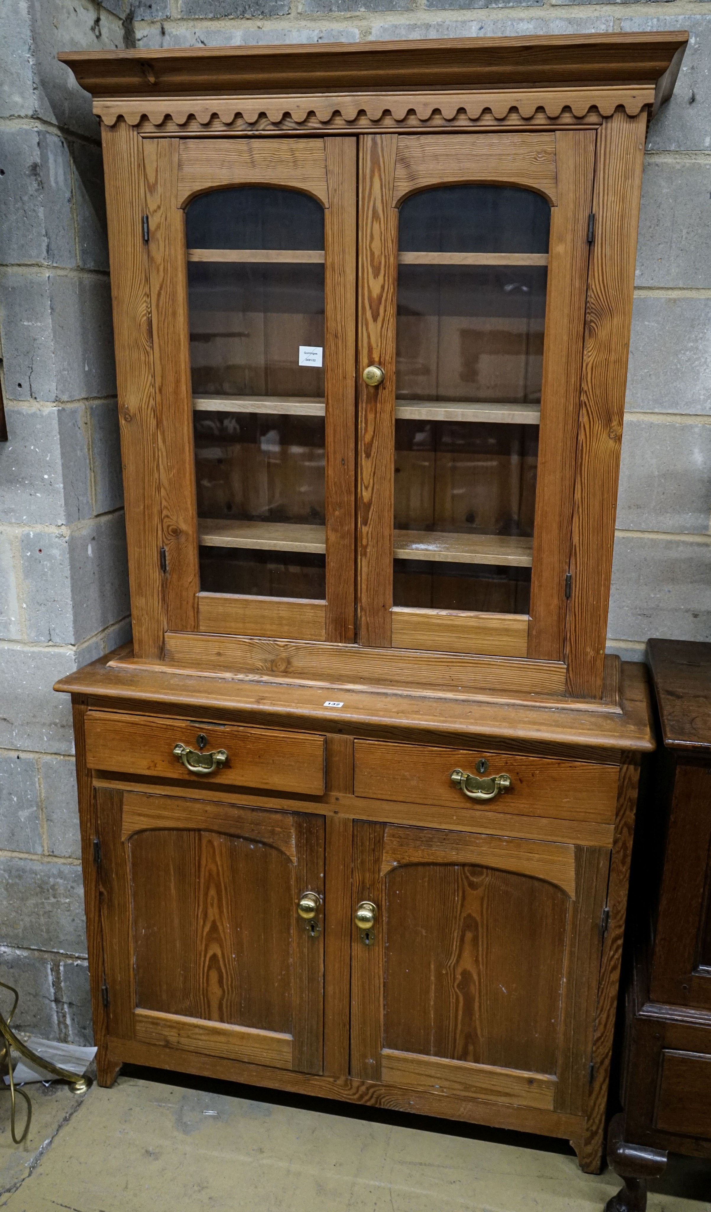 An Edwardian pine dresser, with two glazed doors over two drawers and panelled doors, width 107cm, depth 43cm, height 194cm